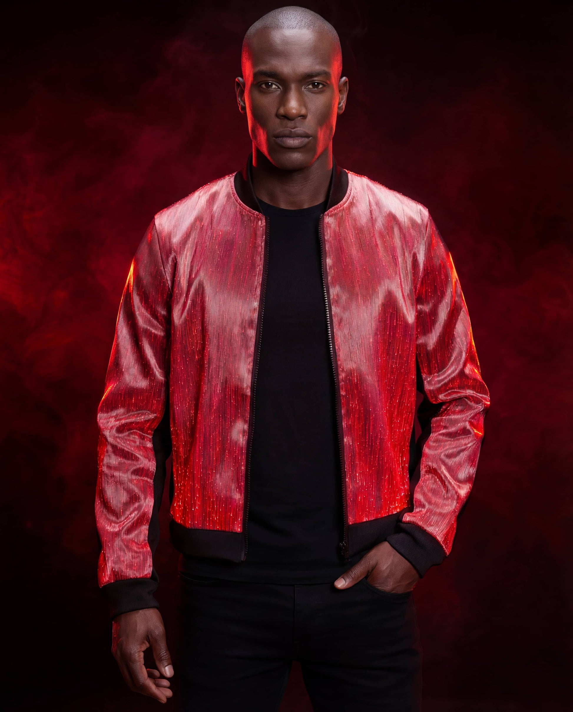 Man wearing a glowing red fiber-optic bomber jacket, standing against a dark red smoke-filled background