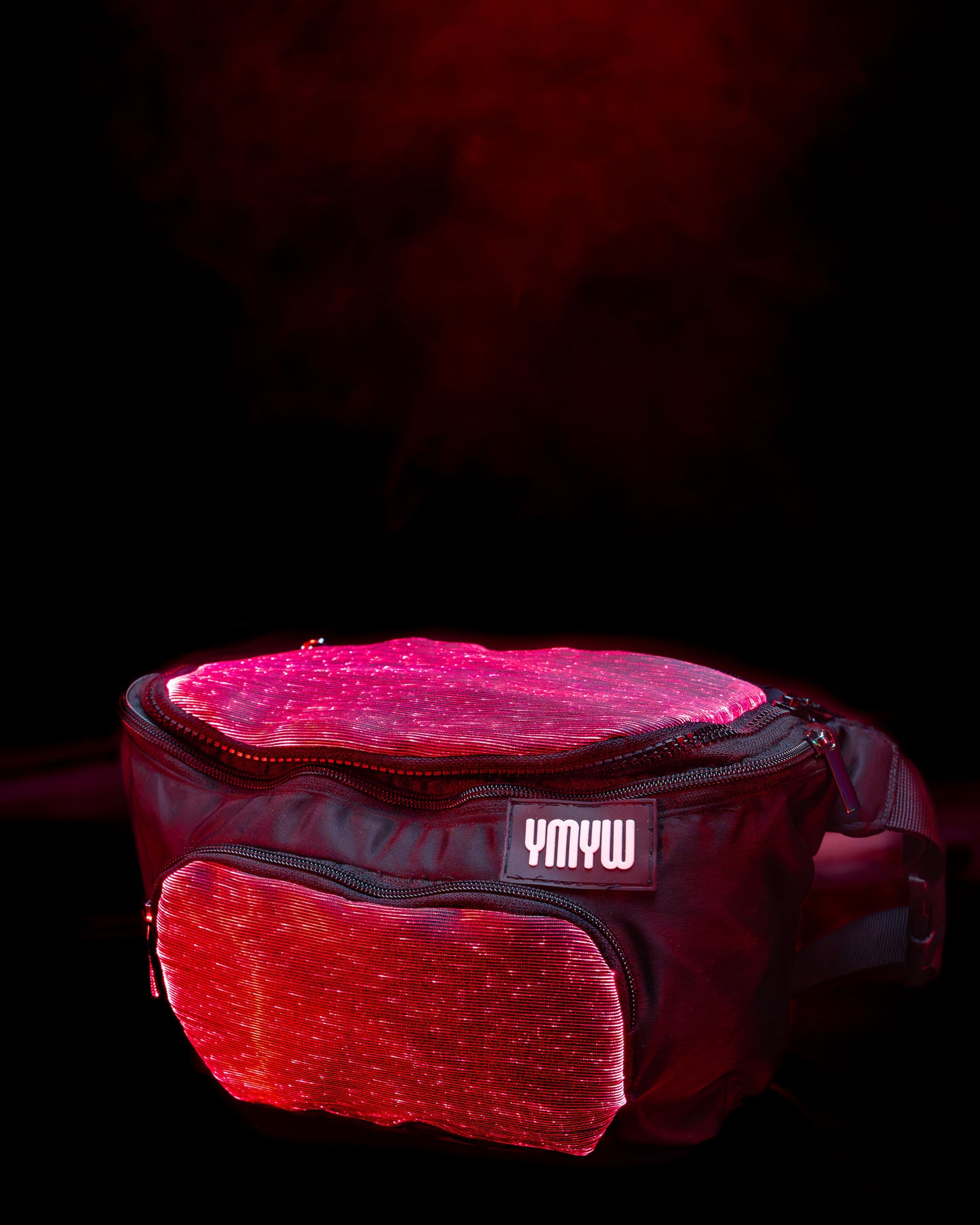 Fiber optic light up waist bag illuminated in red light with "YMYW" branding on a dark background