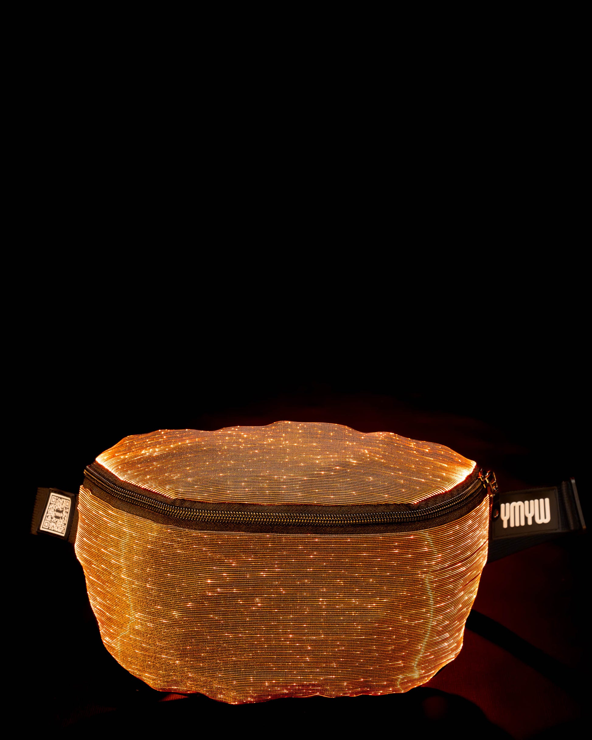 Fiber optic light-up fanny pack illuminated in orange light against a dark background