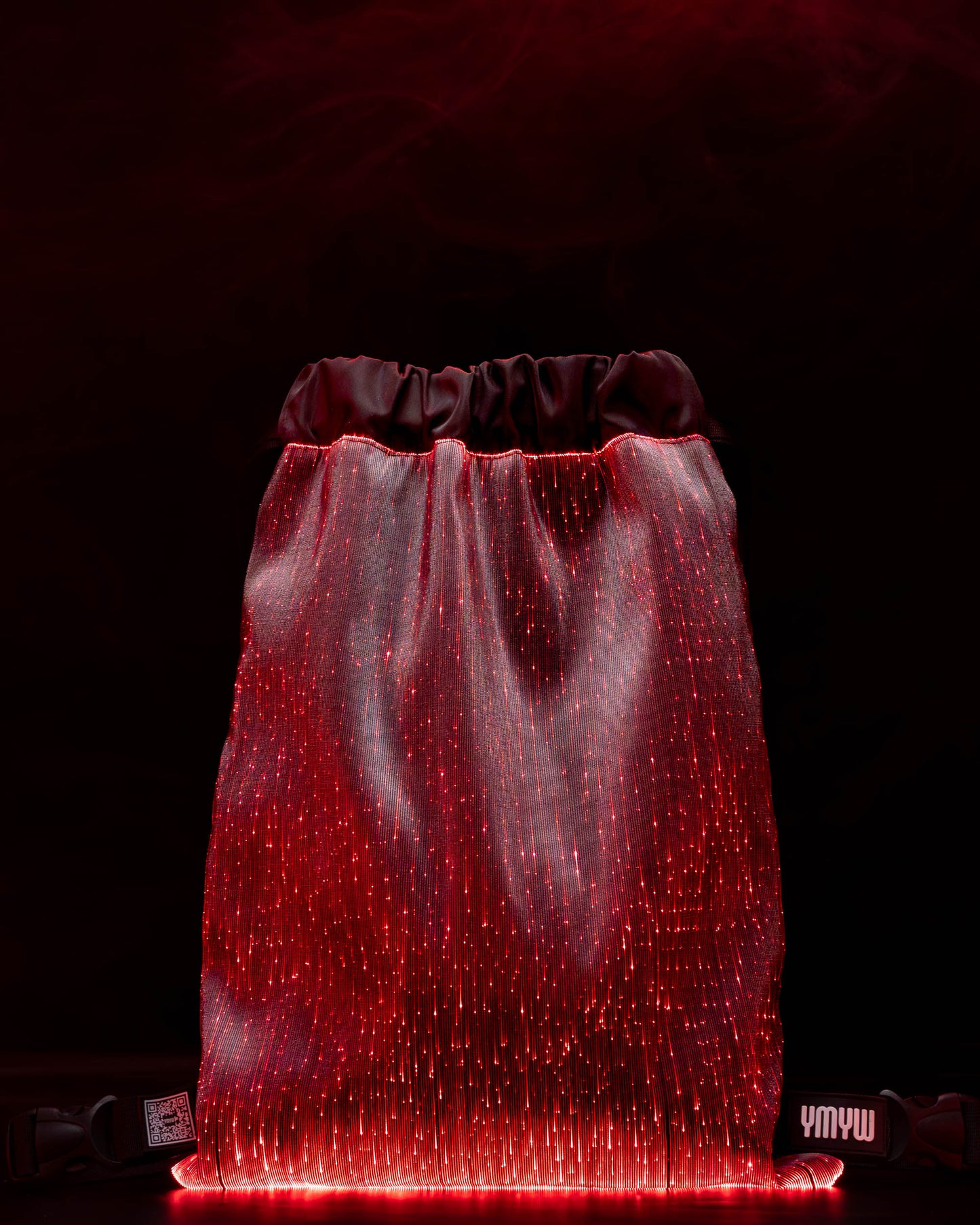 Fiber optic drawstring backpack illuminated in red light against a dark background