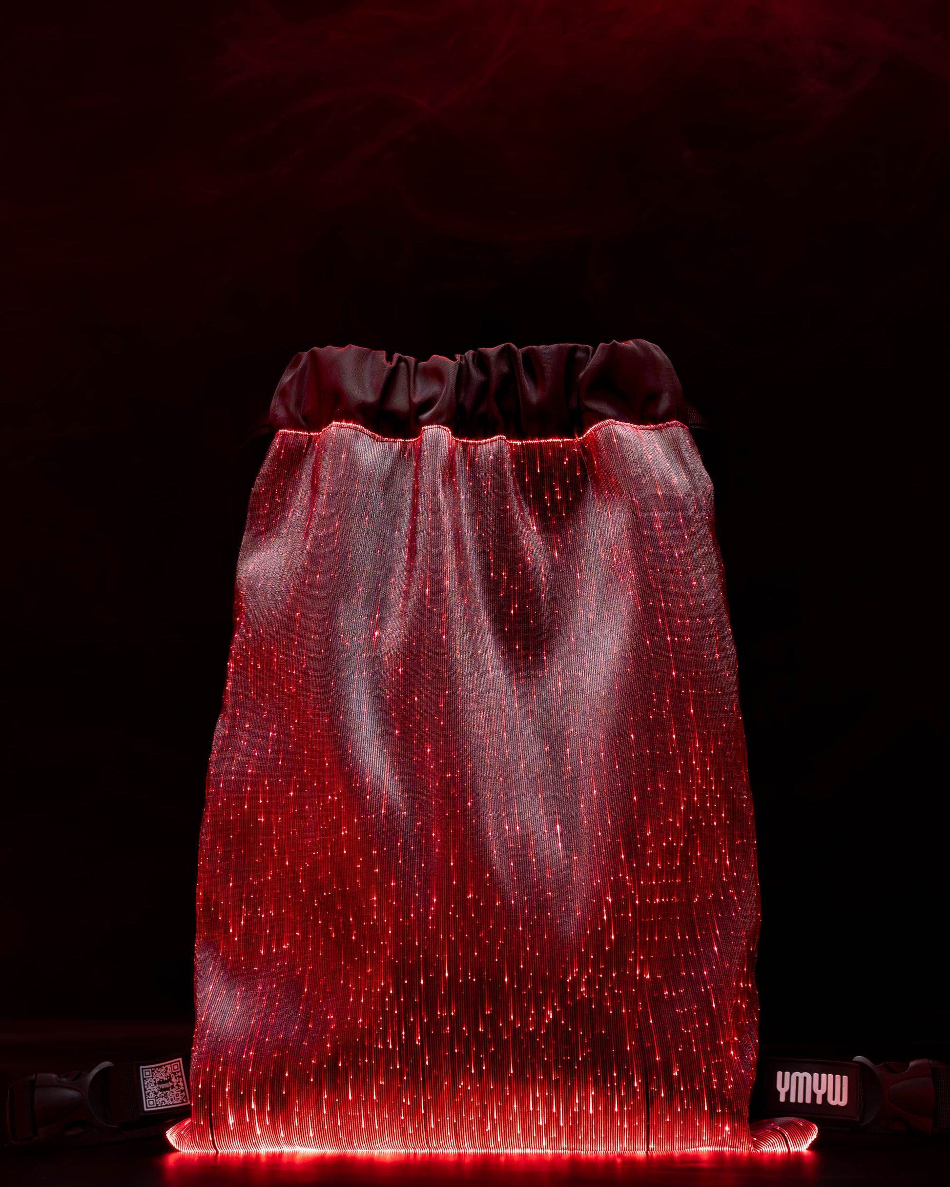 Fiber optic drawstring backpack illuminated in red light against a dark background