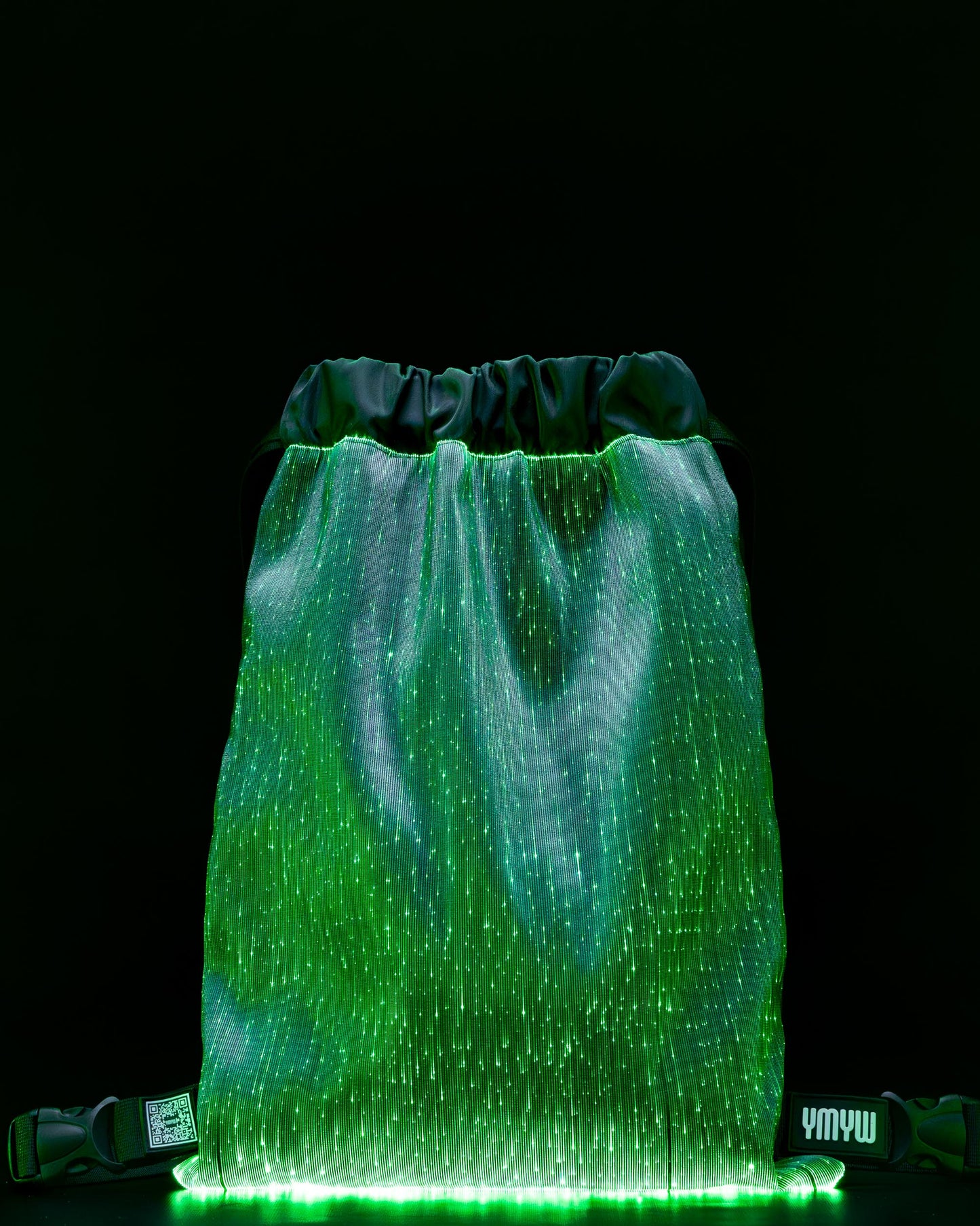Fiber optic drawstring backpack illuminated in green light against a dark background
