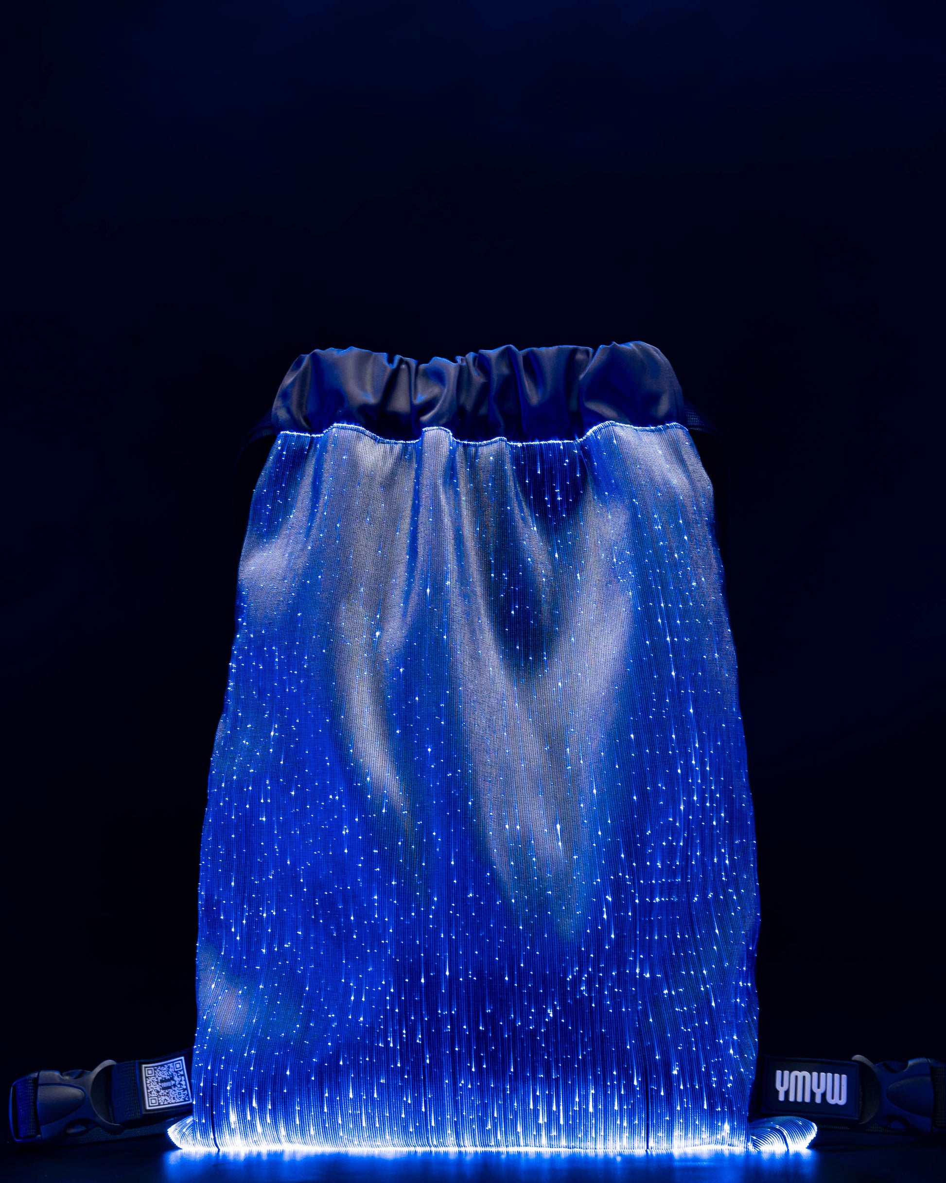 Fiber optic drawstring backpack illuminated in blue light against a dark background