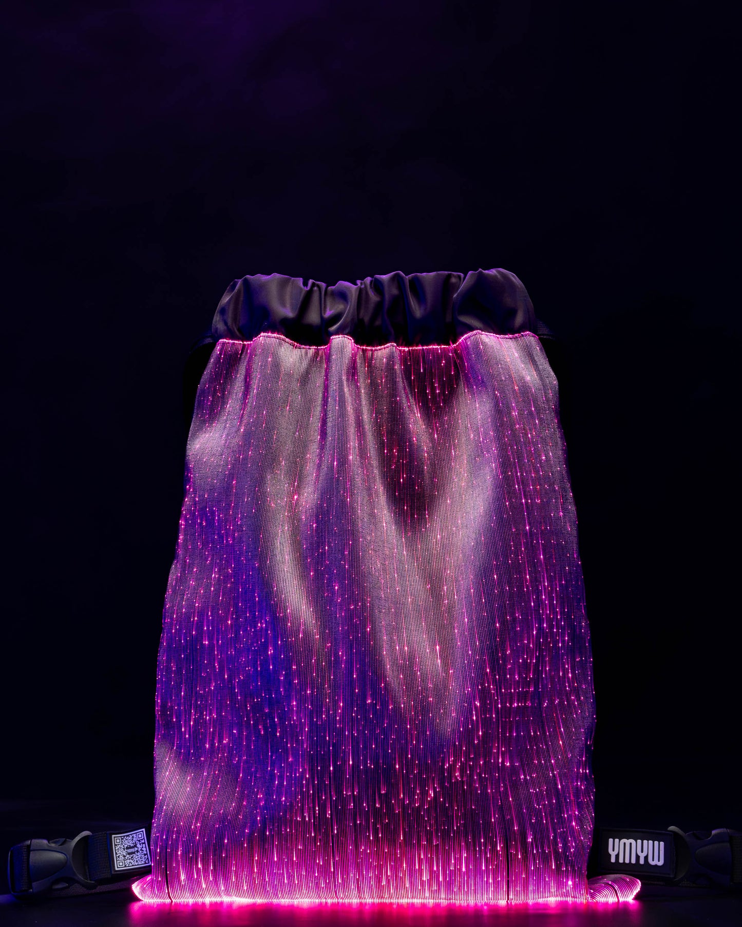 Fiber optic drawstring backpack illuminated in purple light against a dark background