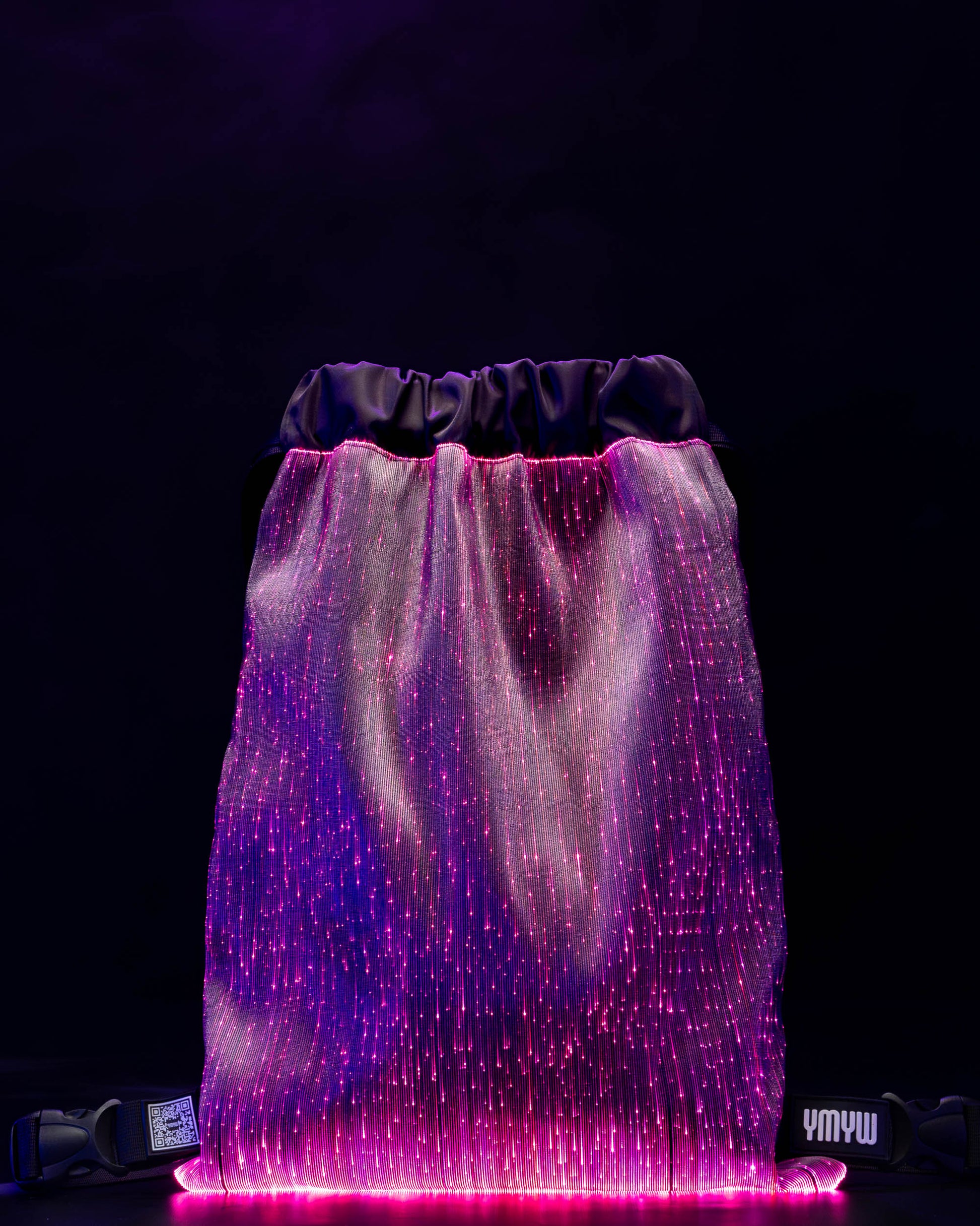 Fiber optic drawstring backpack illuminated in purple light against a dark background