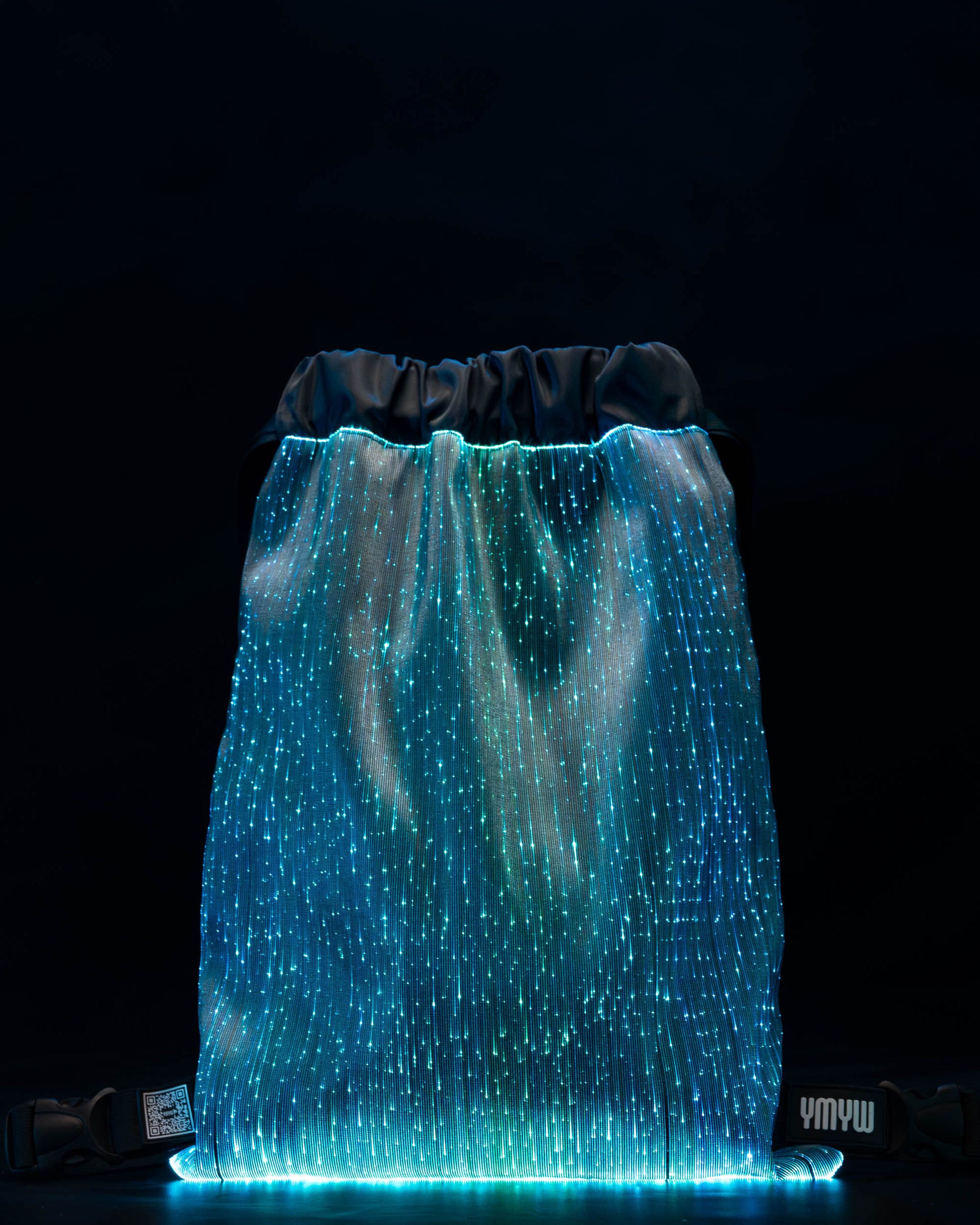 Fiber optic drawstring backpack illuminated in light blue against a dark background