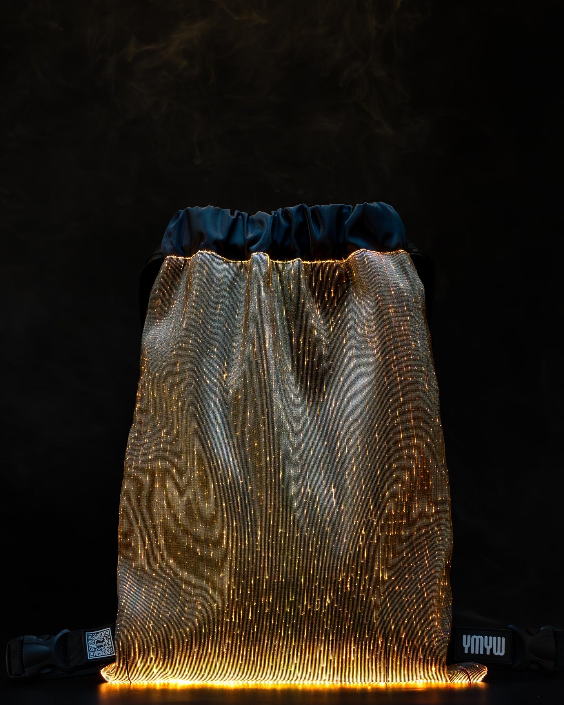 Fiber optic drawstring backpack illuminated in orange light against a dark background