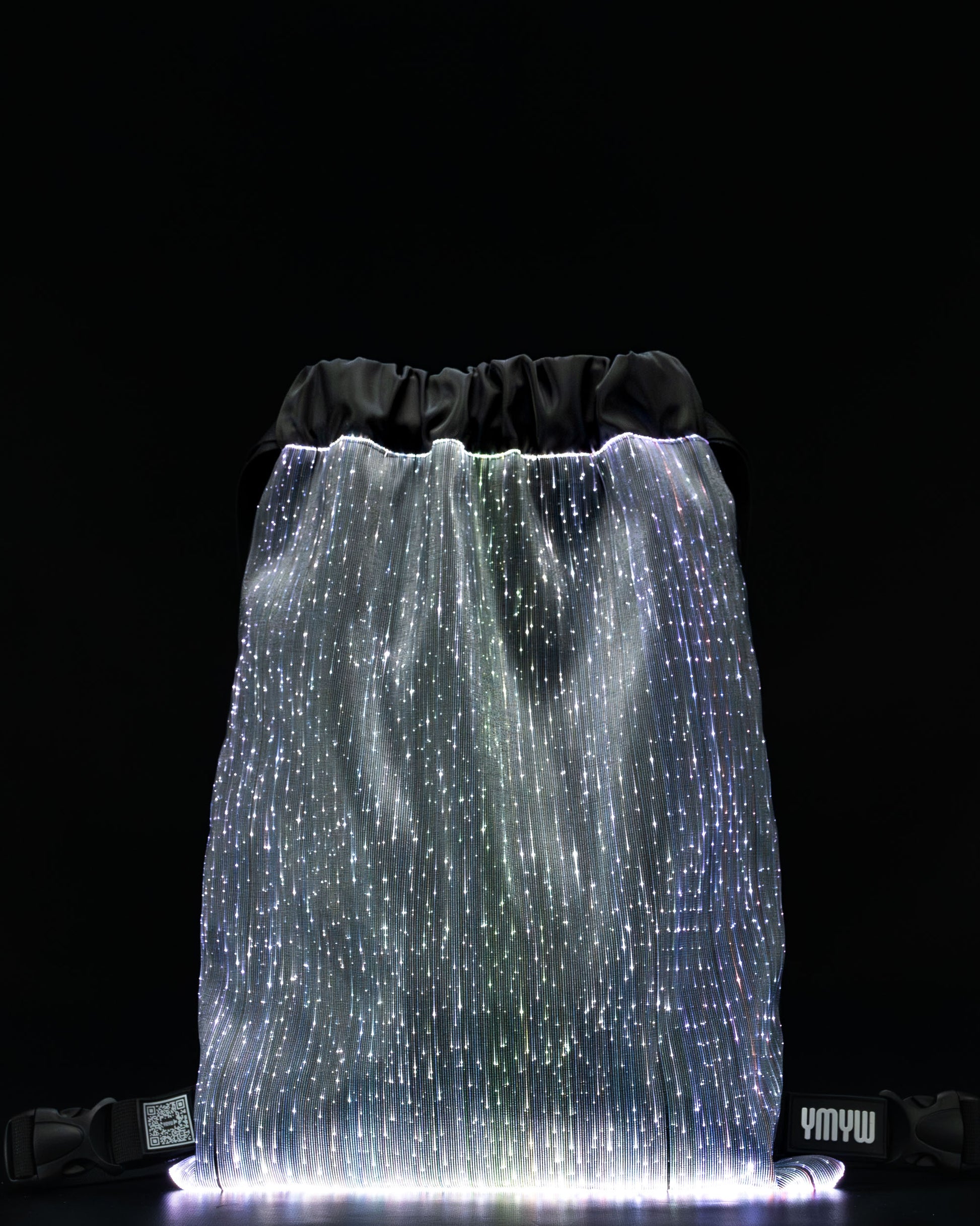 Fiber optic drawstring backpack illuminated in white light against a dark background
