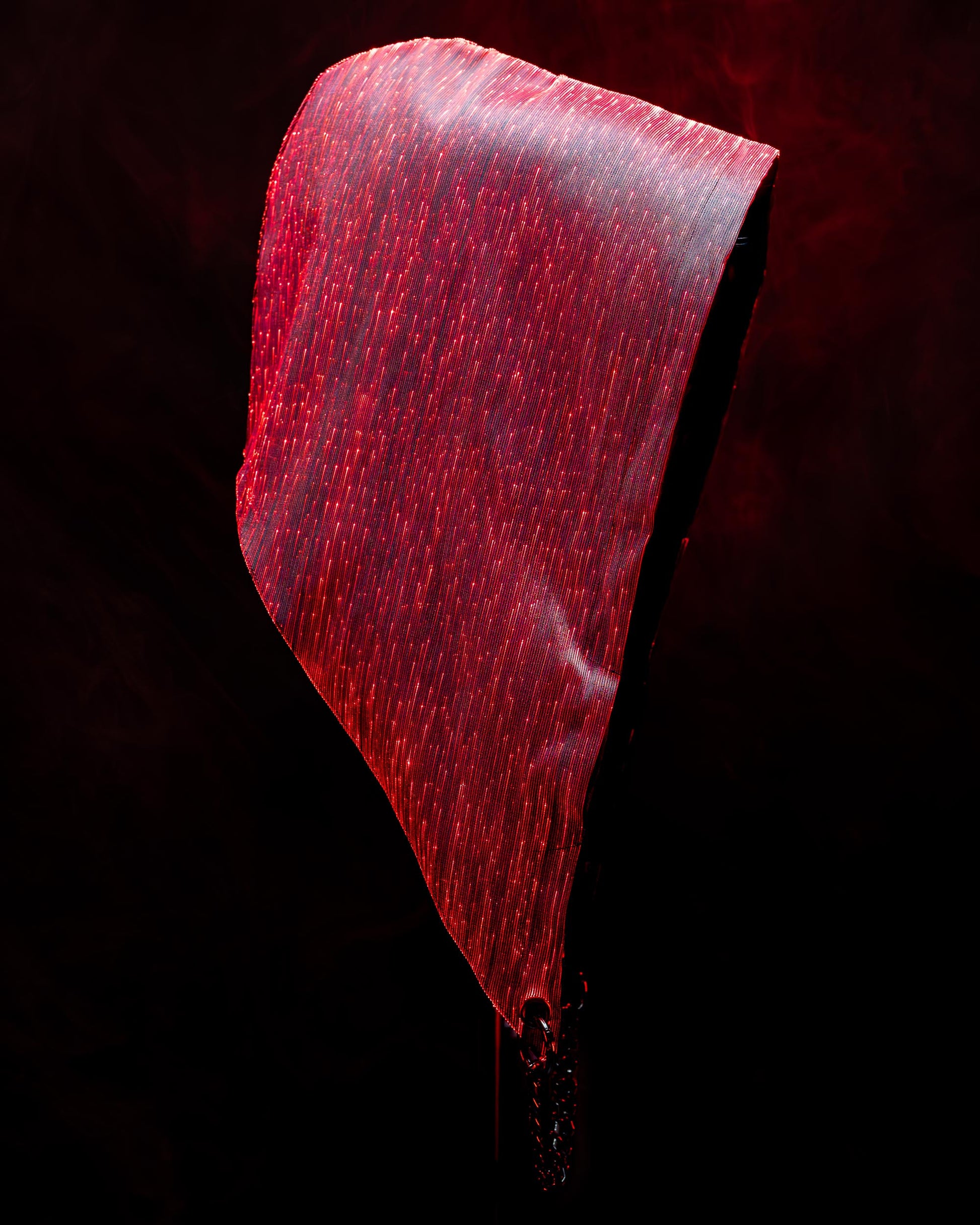 Fiber optic light-up hood illuminated in red light against a dark background