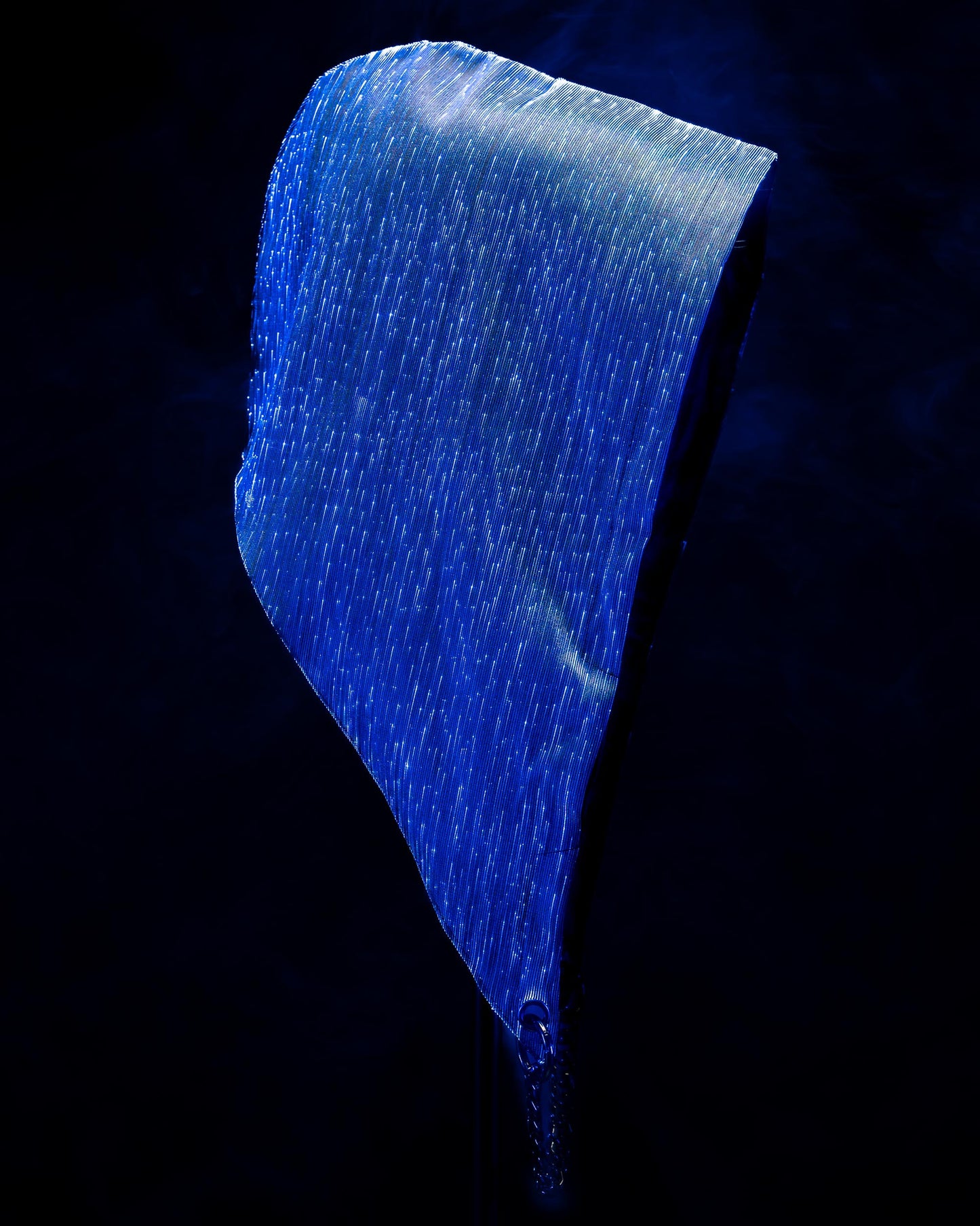 Fiber optic light-up hood illuminated in blue light against a dark background