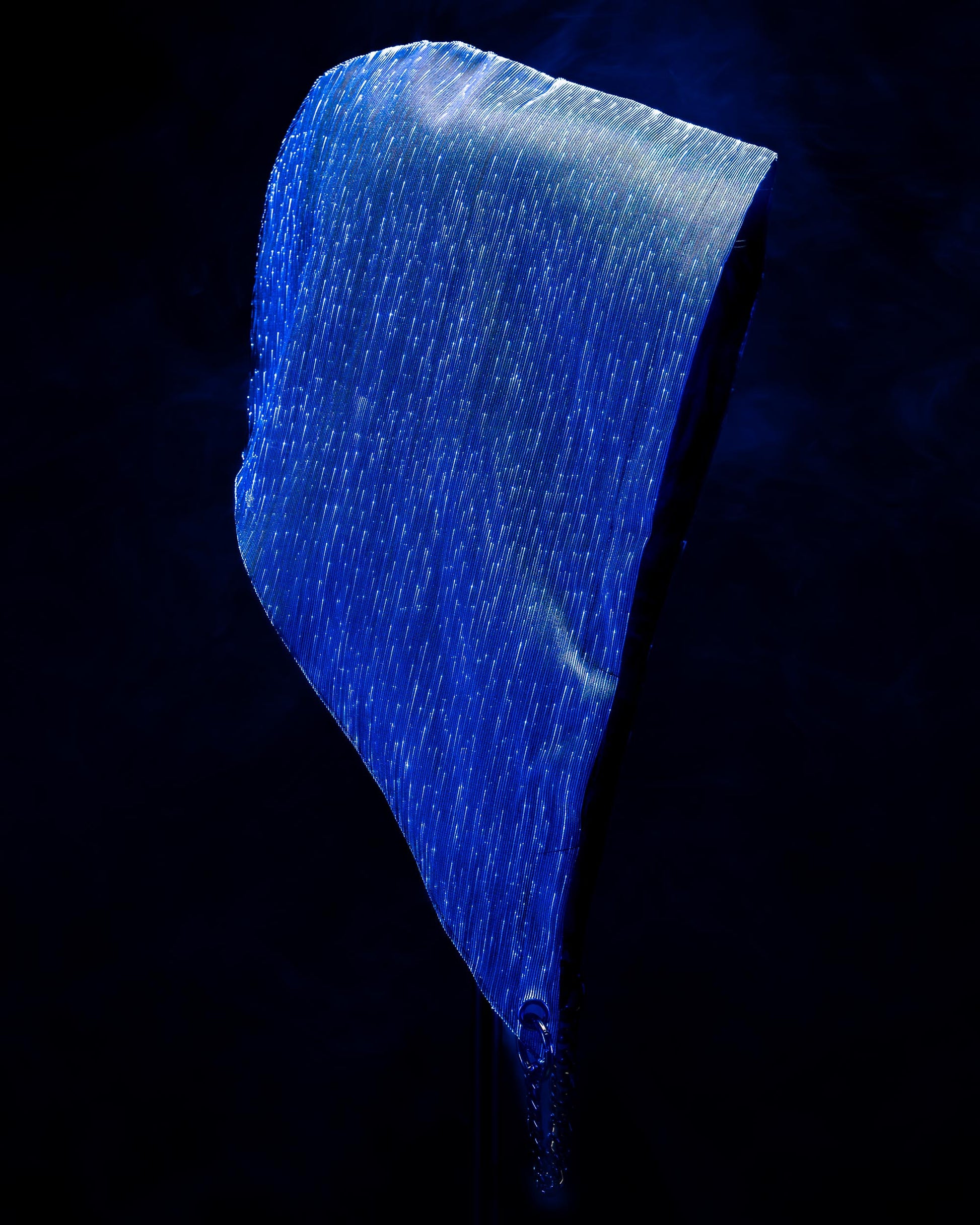 Fiber optic light-up hood illuminated in blue light against a dark background