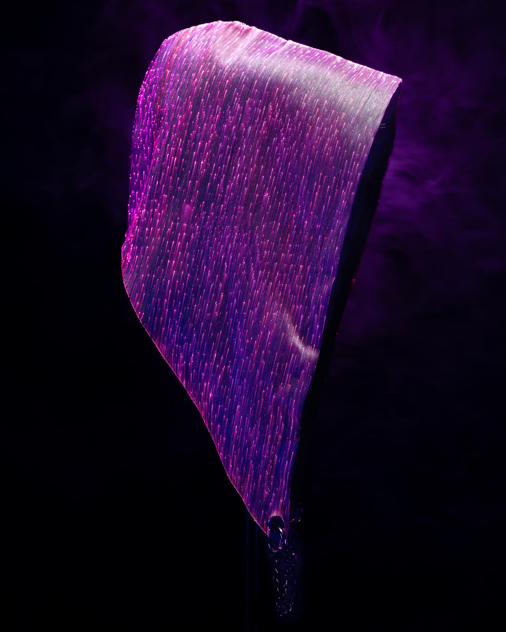 Fiber optic light-up hood illuminated in purple light against a dark background