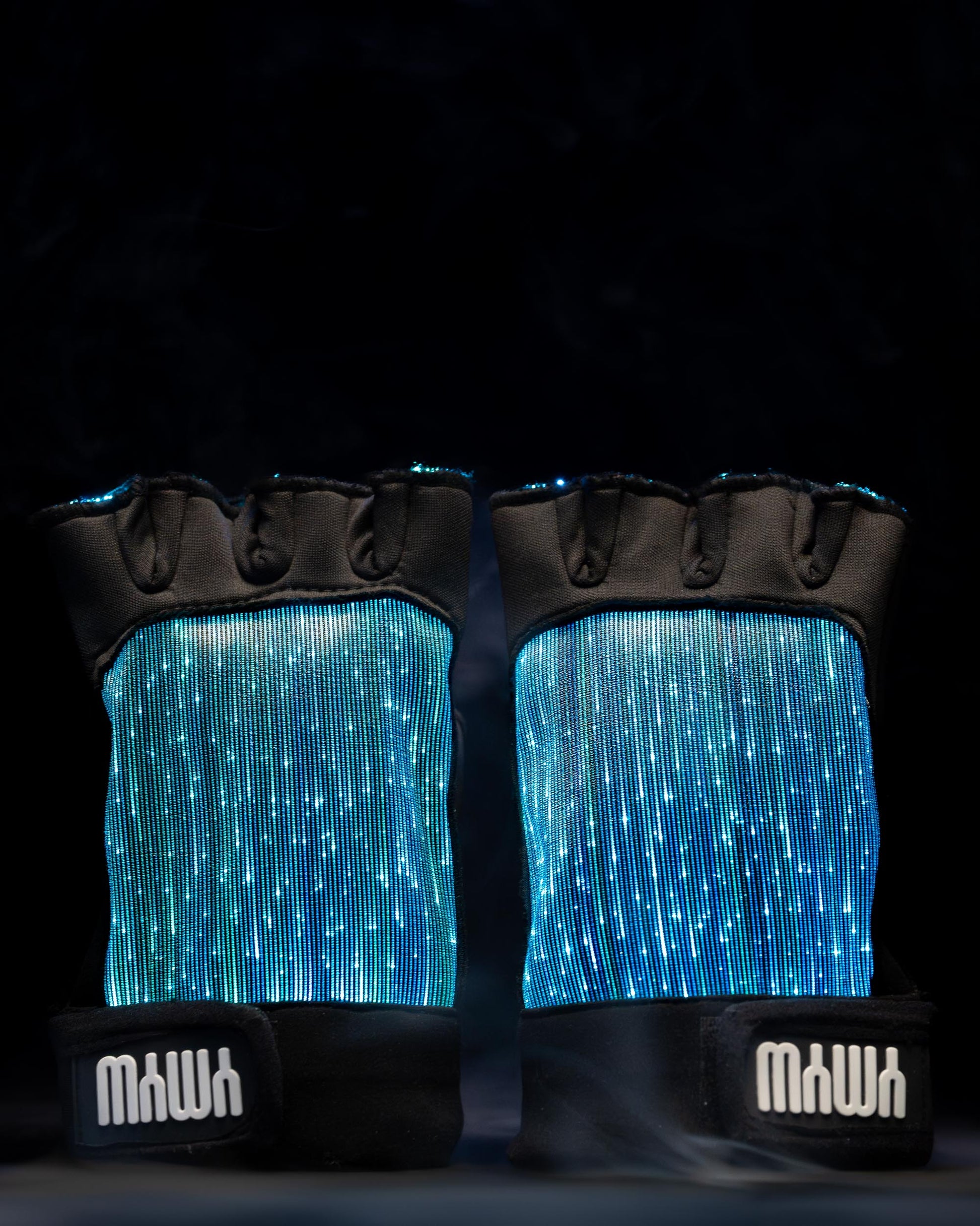 Pair of black fiber optic light up gloves illuminated in blue light against a dark background