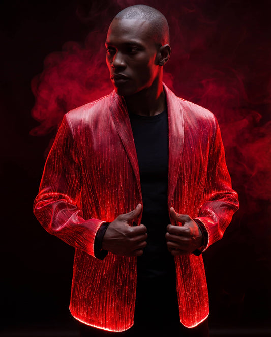 Man wearing a glowing red fiber-optic suit jacket, standing against a dark background with red smoke rising behind him