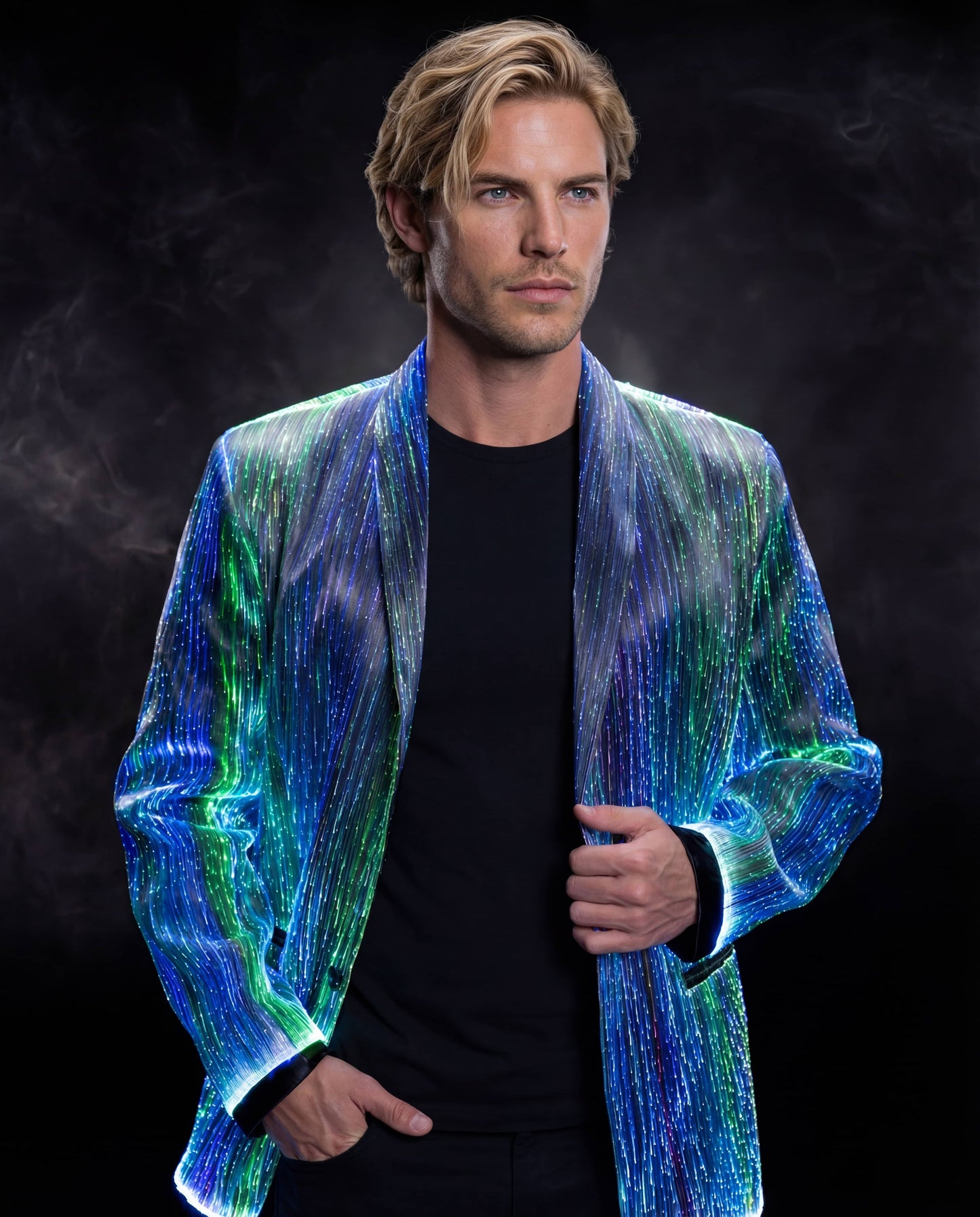Man wearing a glowing blue and green fiber-optic suit jacket, standing against a dark smoky background