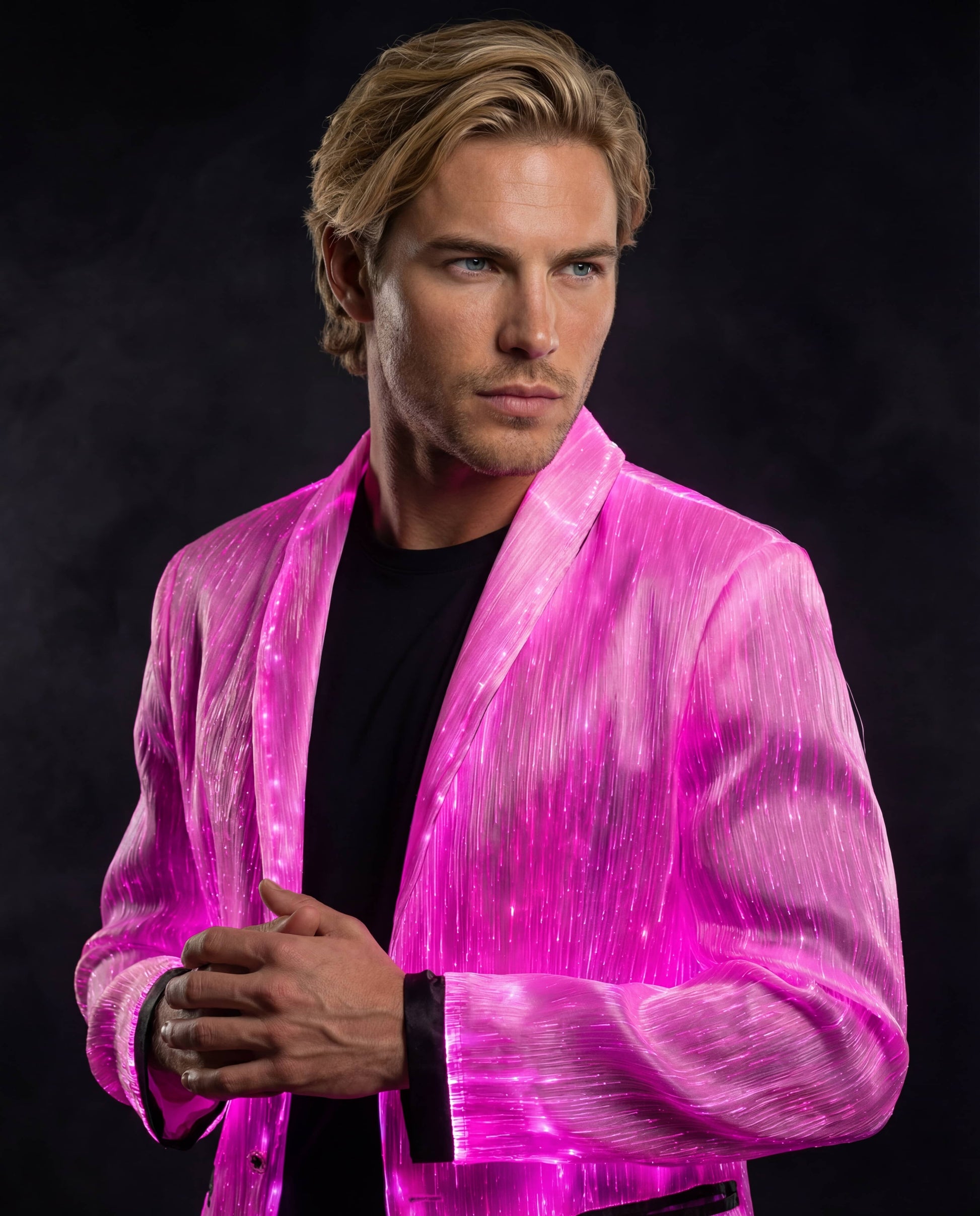 Man wearing a glowing pink fiber-optic suit jacket, standing against a dark smoky background with his hands clasped at the front