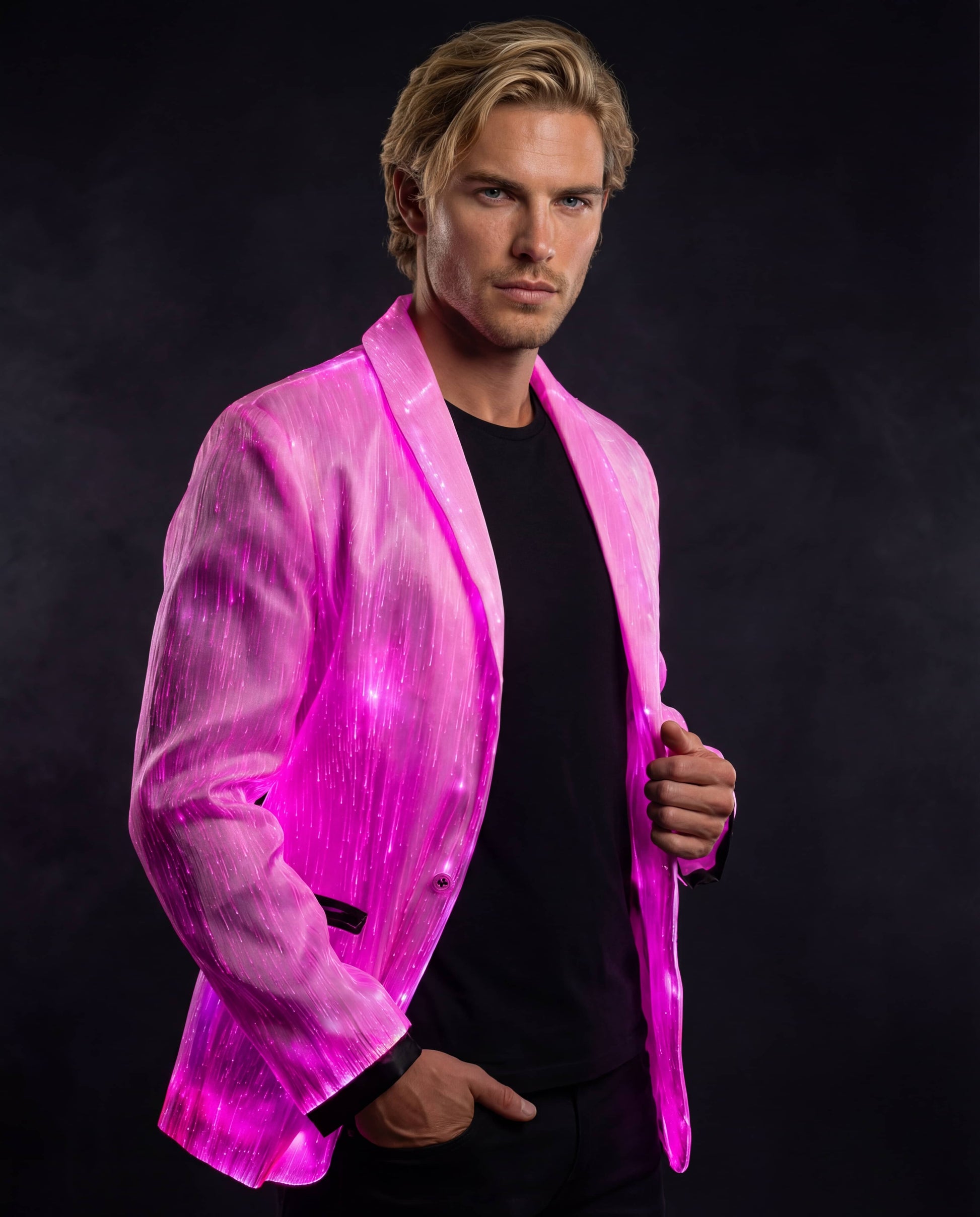 Man wearing a glowing pink fiber-optic suit jacket, standing against a dark smoky background with one hand in his pocket