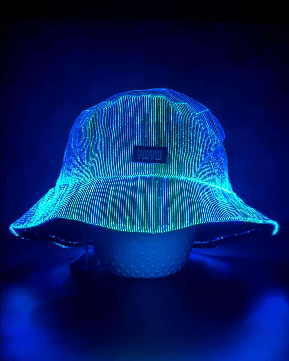 Fiber optic light up bucket hat glowing in vivid blue LED colors on a dark background