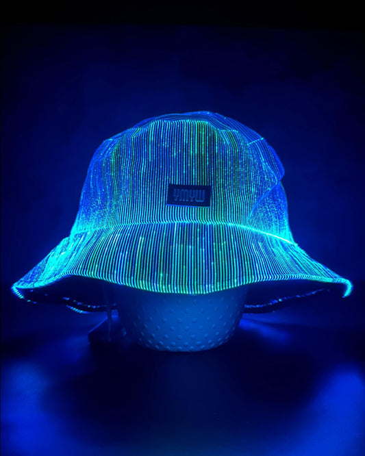 Fiber optic light up bucket hat glowing in vivid blue LED colors on a dark background