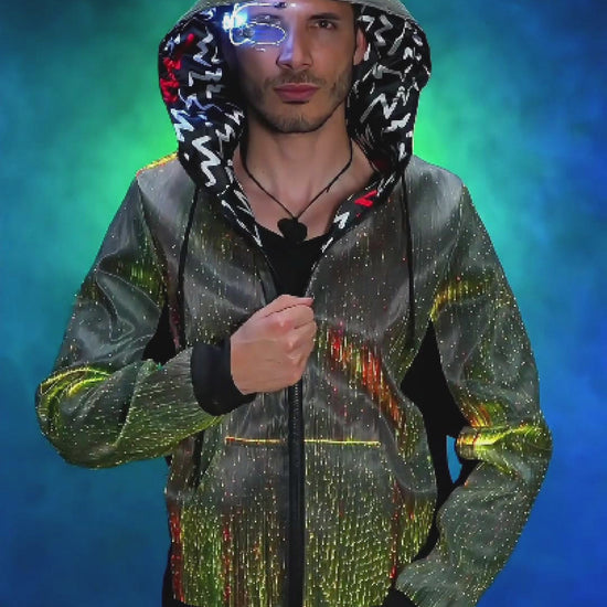 Man wearing a fiber optic LED hoodie with the hood up, rotating slowly on a platform as the jacket glows in shifting colors against a colorful, smoky background
