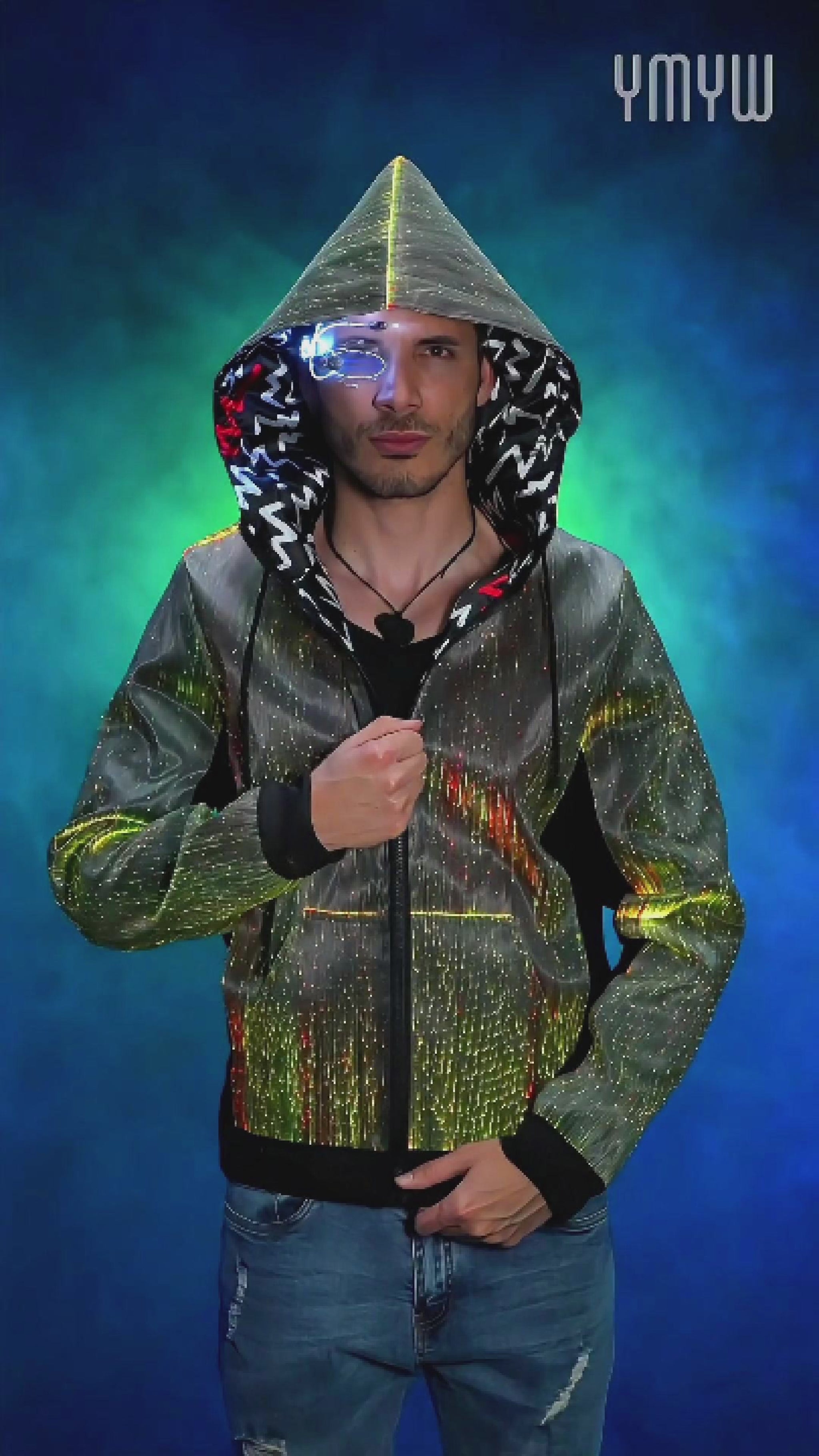 Man wearing a fiber optic LED hoodie with the hood up, rotating slowly on a platform as the jacket glows in shifting colors against a colorful, smoky background