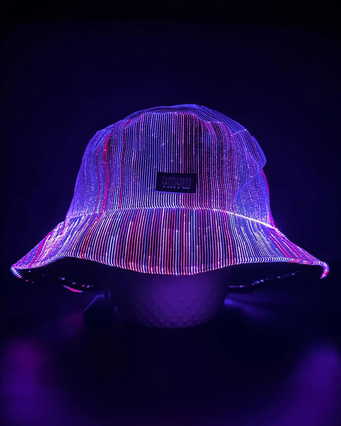Fiber optic light up bucket hat glowing in vivid purple LED colors on a dark background