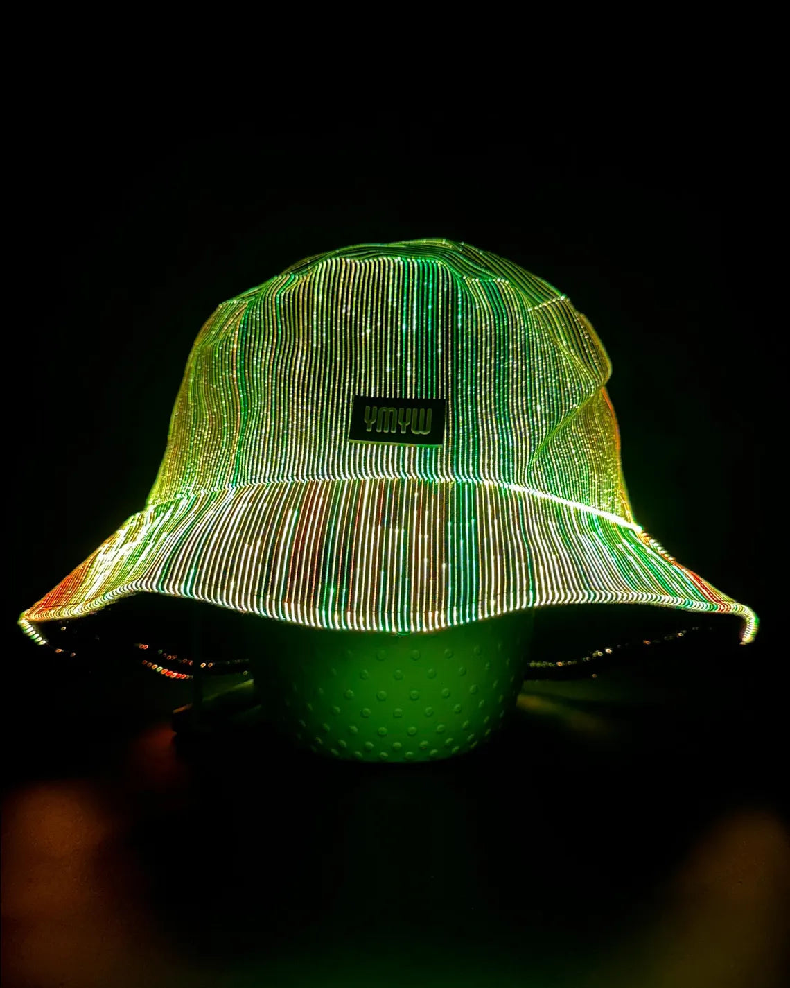 Fiber optic light up bucket hat glowing in vivid LED colors on a dark background